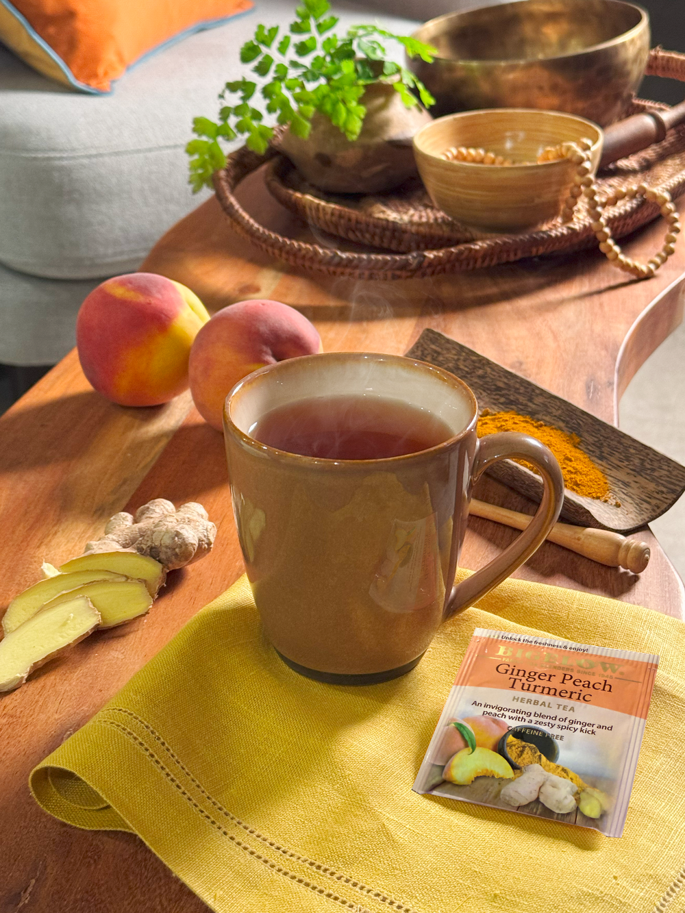 Tea cup with ginger peach turmeric mix on a wooden table with peaches and spices.