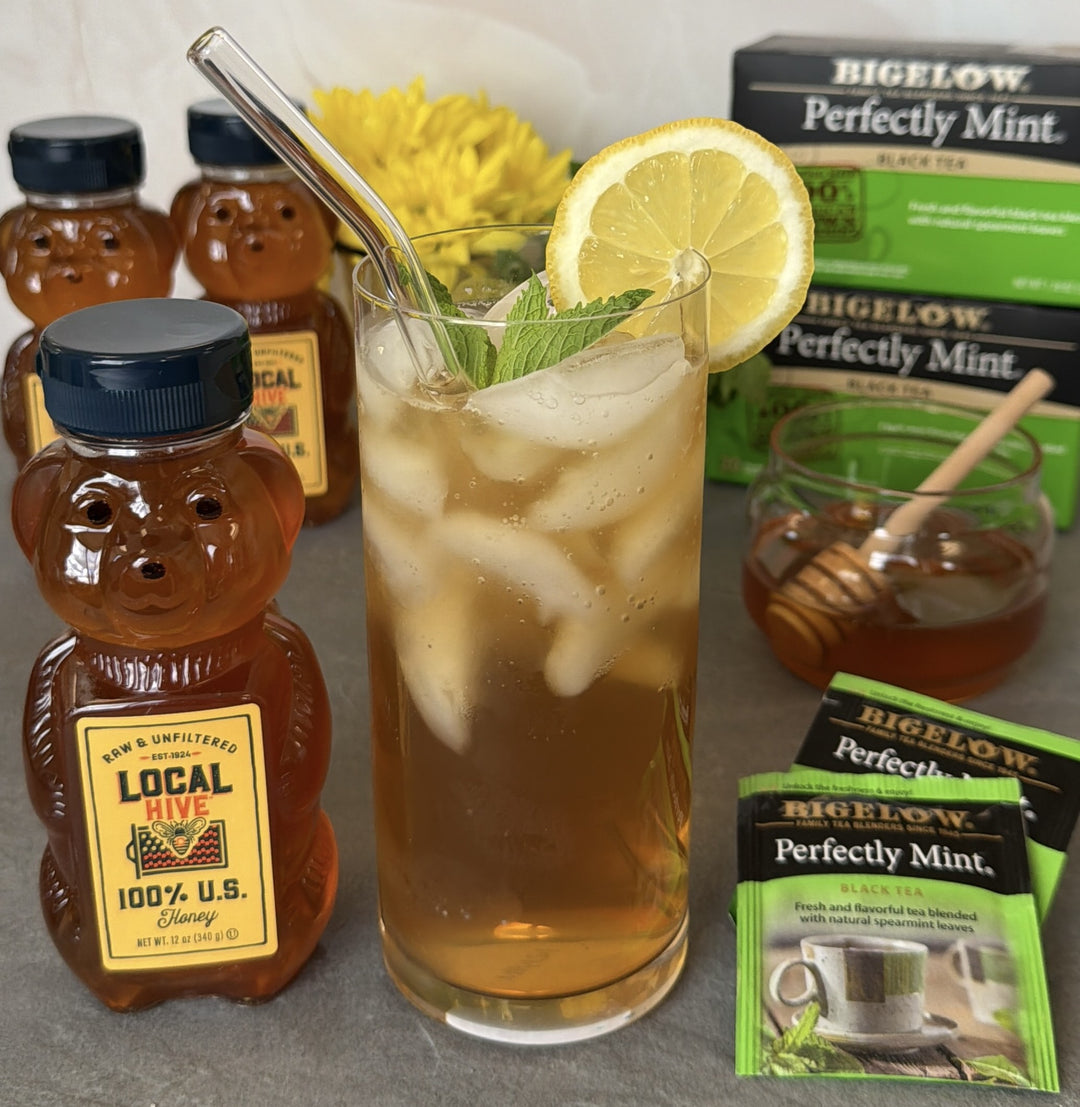 Perfectly Mint Honey Iced Tea in glass with ice and bear container of honey