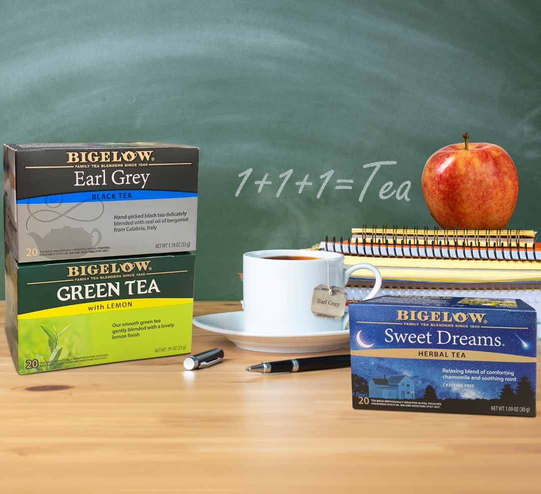 Bigelow Earl Grey, Green Tea with Lemon and Sweet Dreams tea with cup and saucer, stack of books, apple with chalkboard background