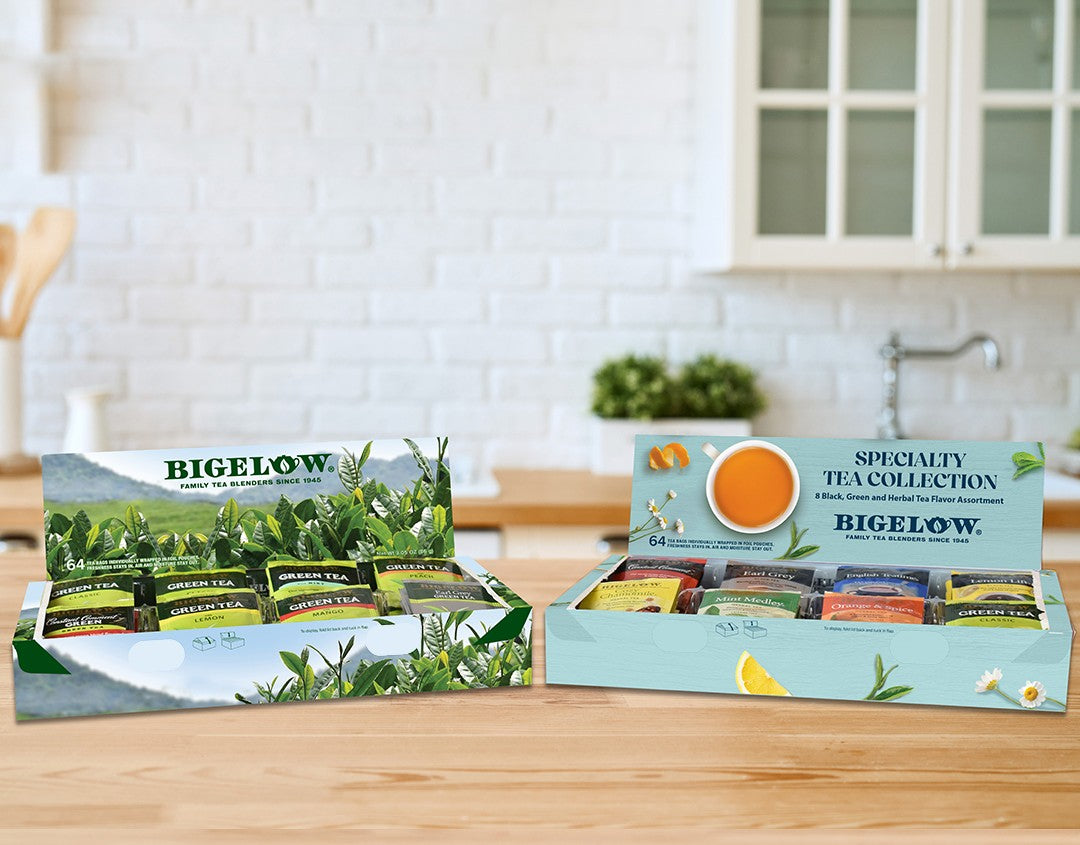 Bigelow Logo Wooden Tea Chest with 8 different teas in holiday lights background with cup of tea