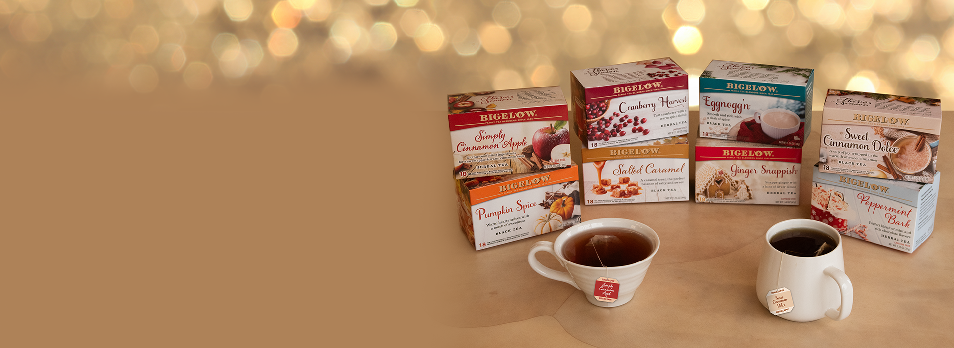 Tea boxes and cups on a wooden surface with a warm, blurred background