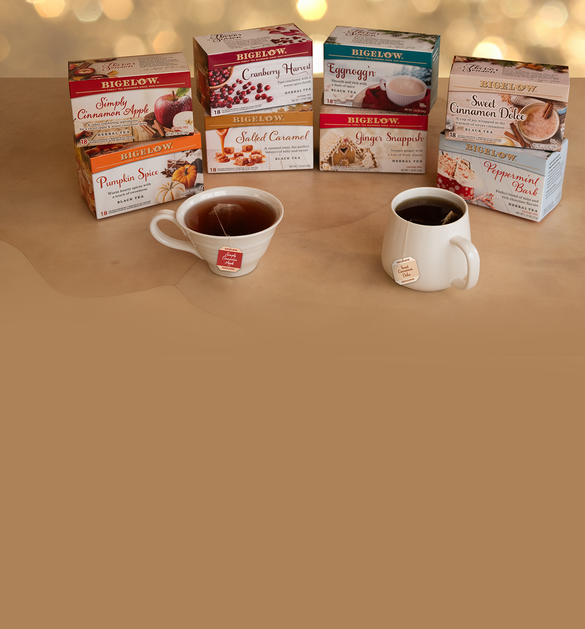 Bigelow tea boxes with two cups of tea on a beige surface