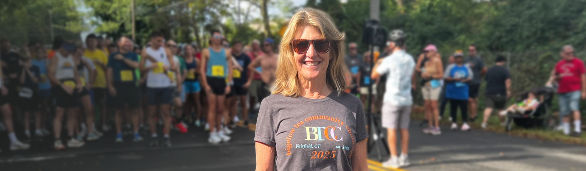 Cindi Bigelow in a gray t-shirt with a logo at a running event Bigelow Tea Community Challenge