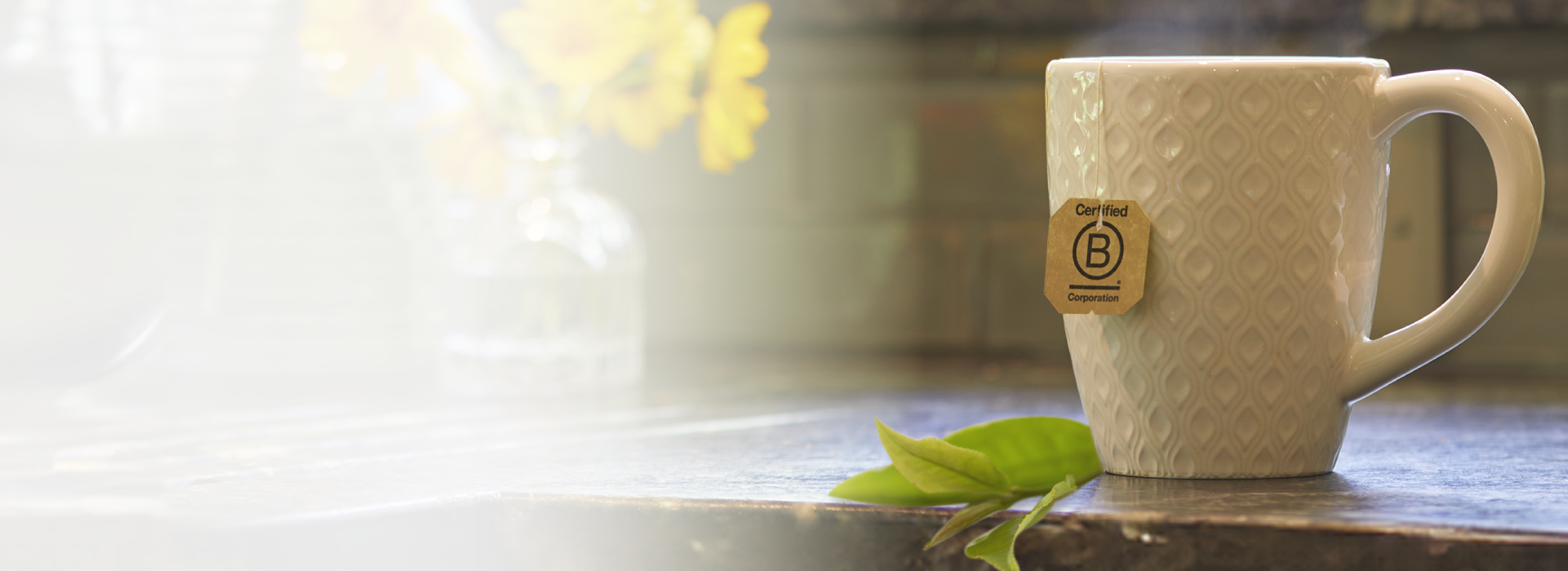 White textured mug with a wooden label on a wooden surface with a blurred background