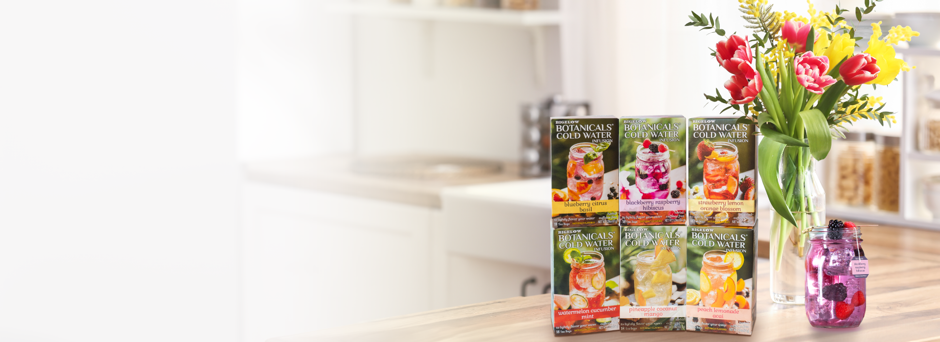 Bouquets of the Month subscription boxes on a table with flowers and a vase.