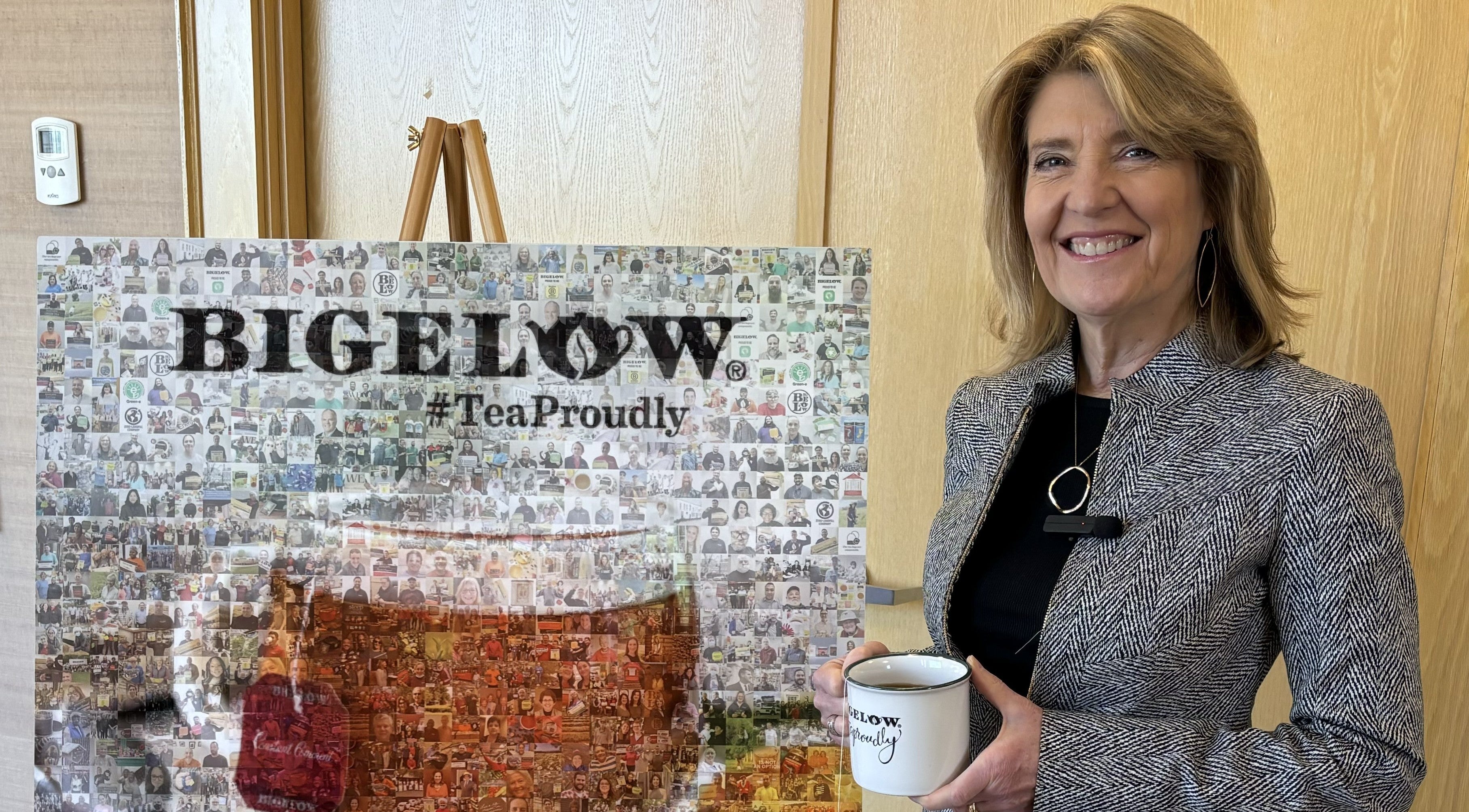Woman holding a mug in front of a Bigelow tea display