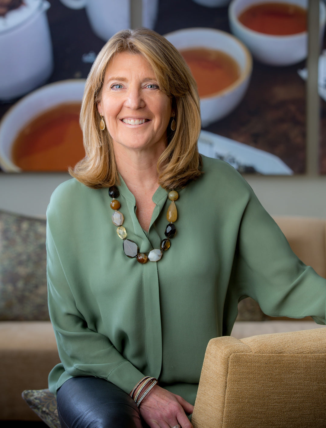 Cindi Bigelow sitting in lobby with pictures of tea in background