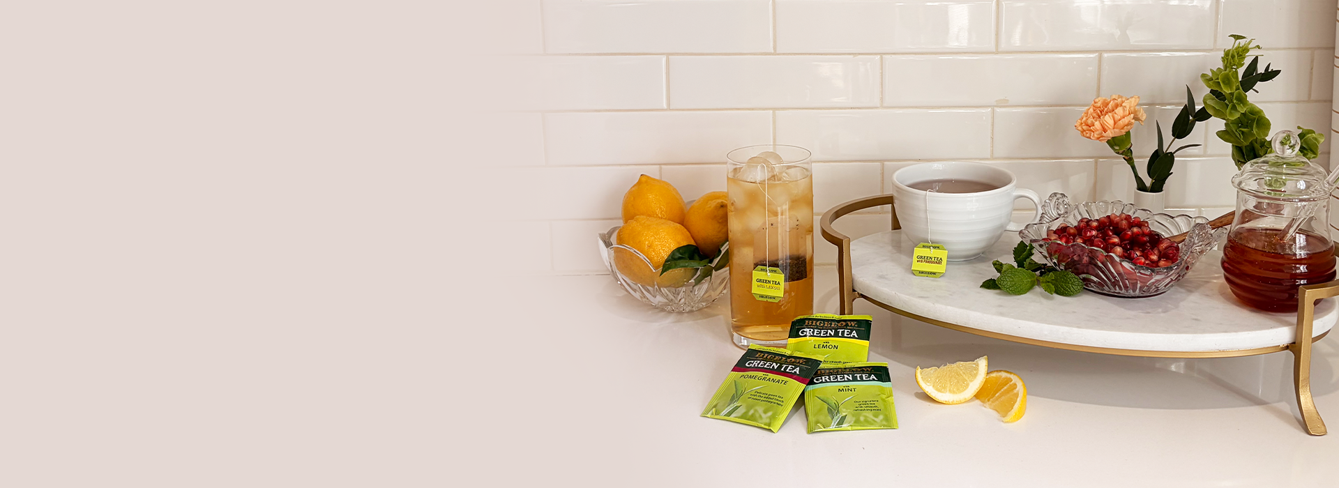 Tea setup with cups, teabags, and lemon slices on a white surface.
