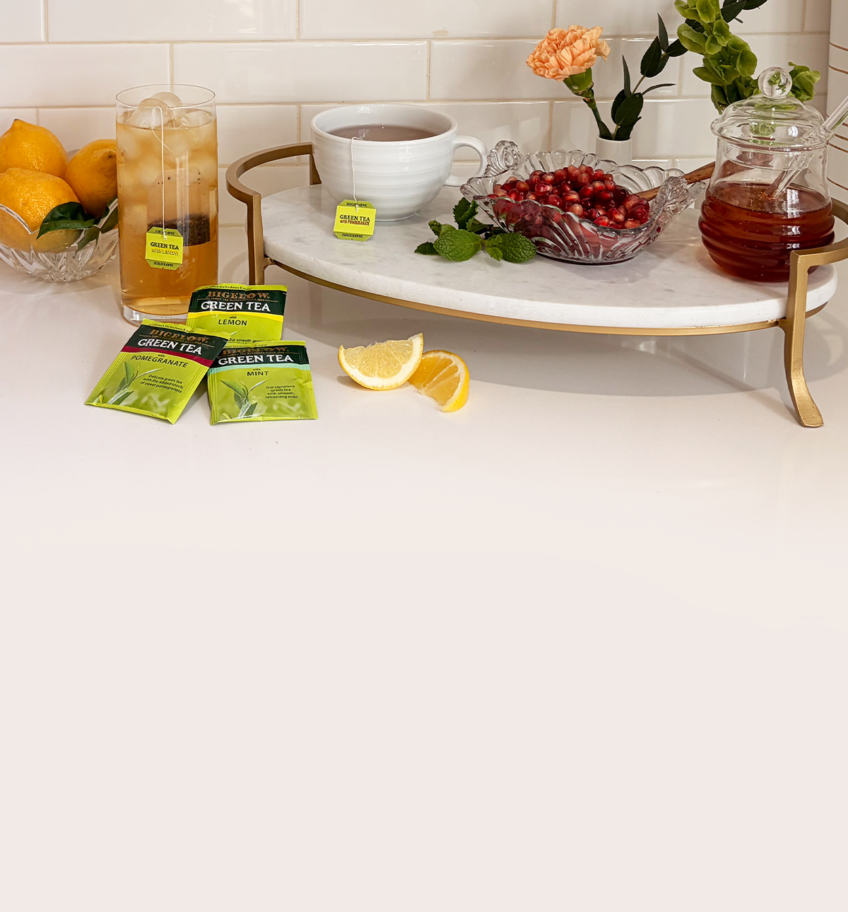 Tea setup with lemon slices, green tea packets, and a marble tray.