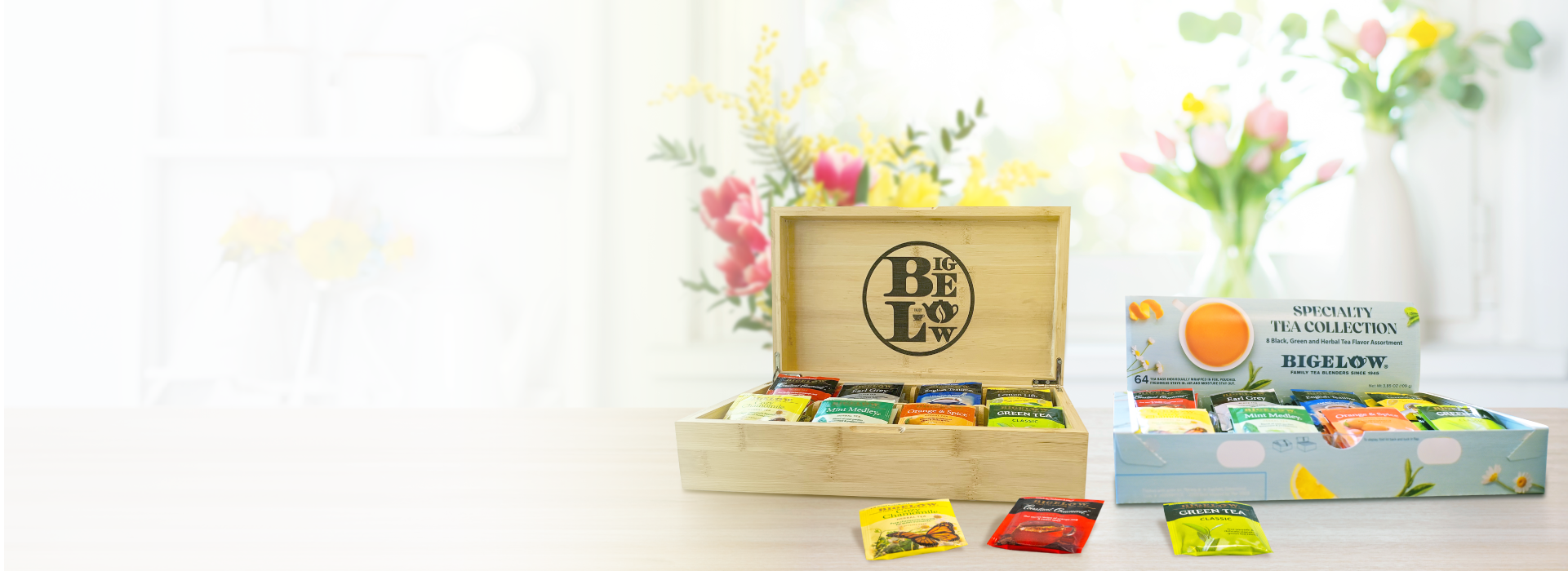 Tea box with assorted tea bags and a bottle of lemon juice on a light background