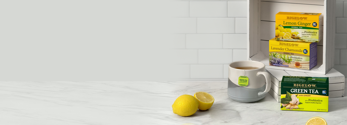4 boxes of Bigelow Probiotic teas on white marble countertop with lemons and mug of tea
