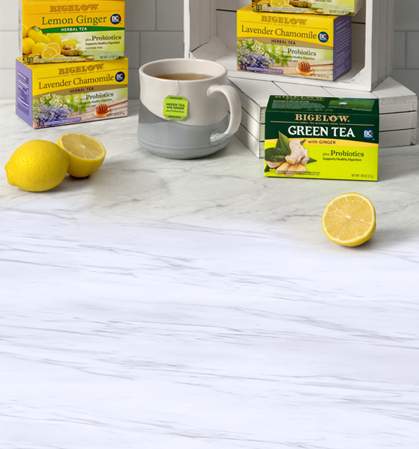 4 boxes of Bigelow Probiotic teas on white marble countertop with lemons and mug of tea