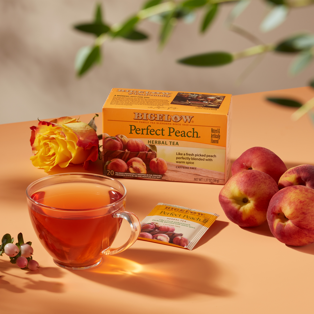 Glass cup of  Perfect Peach Herbal Tea on peach cloth with peach ingredients