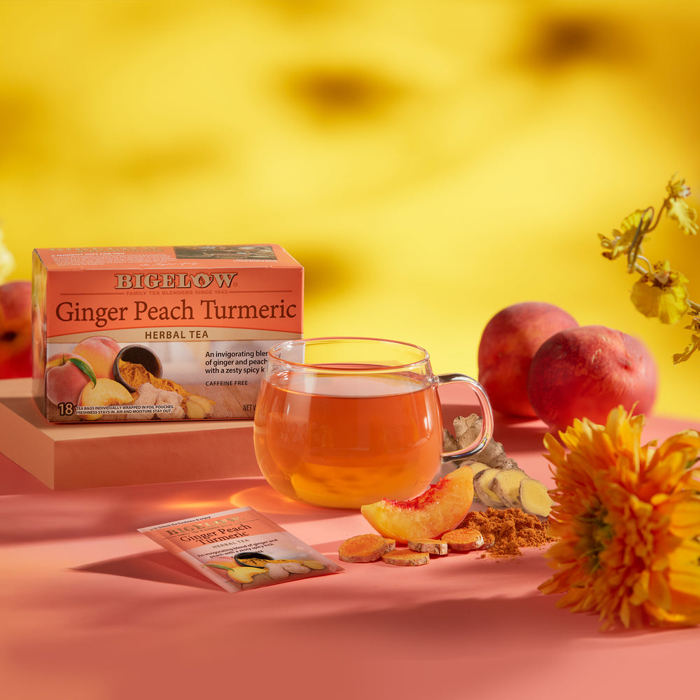 Glass cup of Ginger Peach Turmeric Herbal Tea with peaches