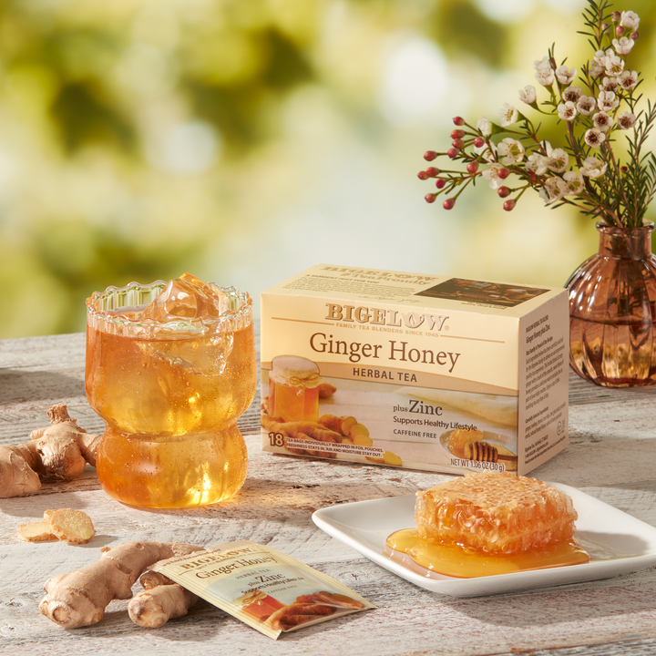 Glass of  iced Ginger Honey Plus Zinc Herbal Tea with box and foil packet