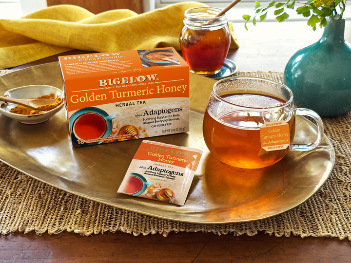 Glass cup of of Bigelow Golden Turmeric Honey Herbal Tea on a tray