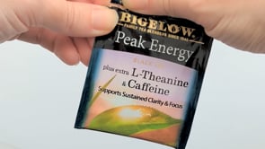 Hand tearing the packet of Bigelow Peak Energy Black Tea