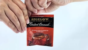 hands opening Constant Comment tea foil wrap