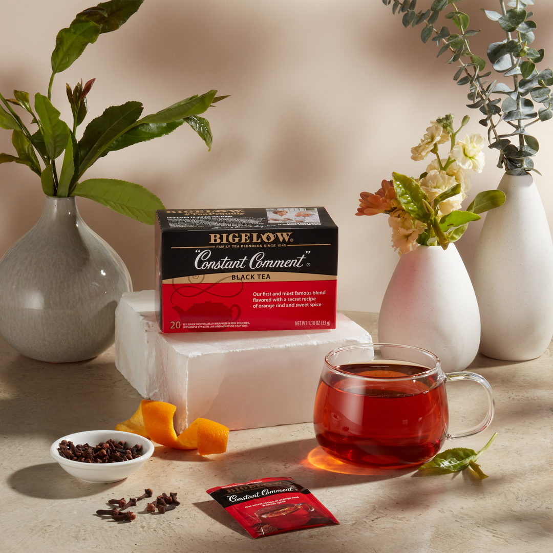 Glass mug  of Constant Comment Tea with box, with ingredients on beige cloth