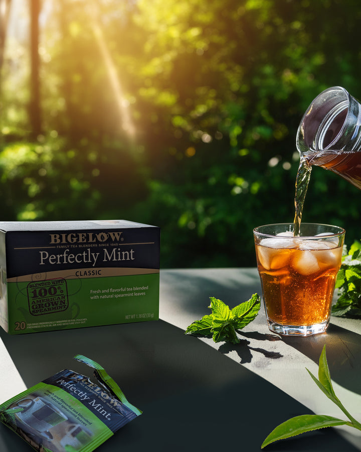 Outside setting with pouring Perfectly Mint Black Tea into glass with ice and box of tea