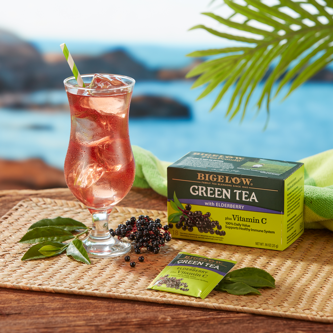 Tropical style Tall Glass of Green Tea with Elderberry plus Vitamin C Iced in tropical setting