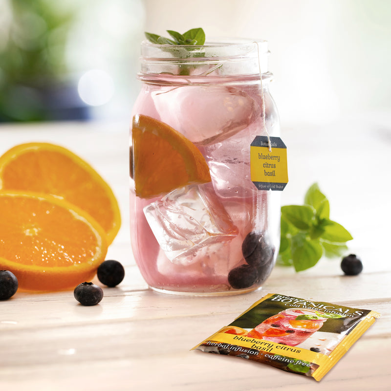 Mason jar filled with Blueberry Citrus Basil Cold Water Infusion with tea box and foil